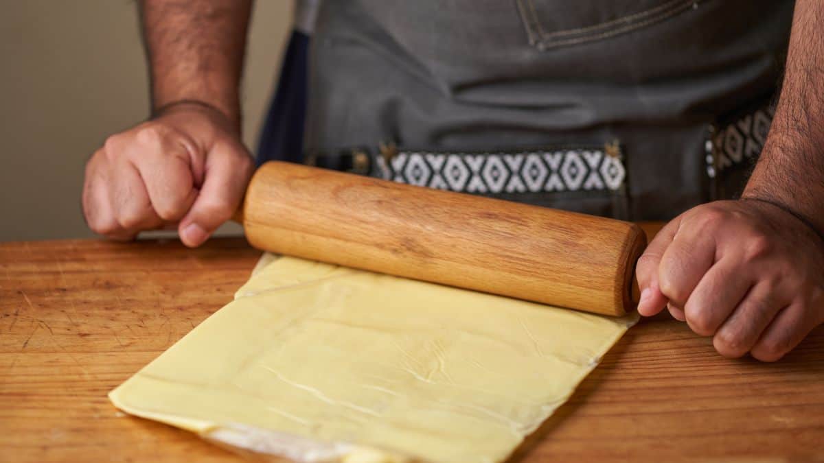 Person rolling the butter placed between two sheets.