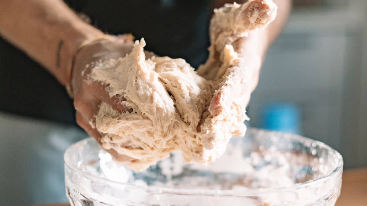 Person handling sticky dough.