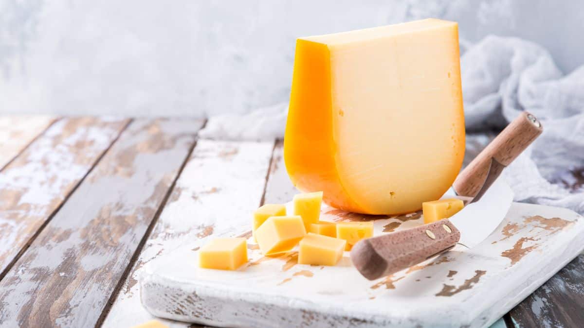 Smoked gouda cheese on a wooden board.