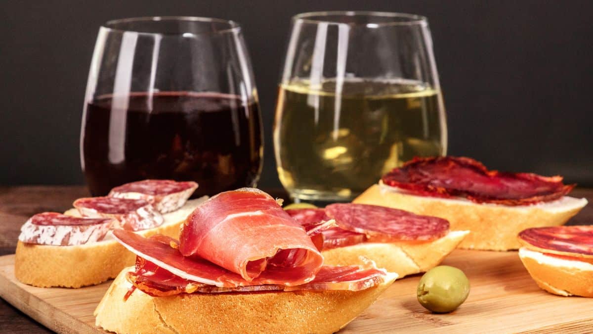 Red and white wine glass on a table with food.