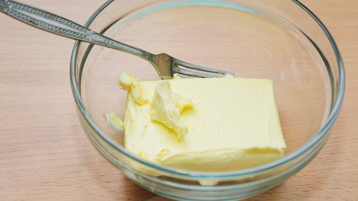 Soft butter in a bowl with a fork.