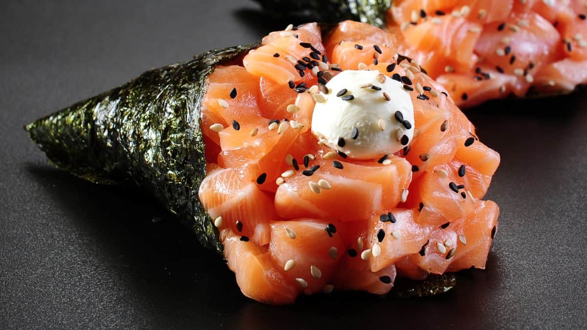 Temako or cone sushi on a black plate.