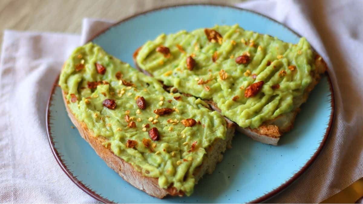 Bacon avocado toast on a blue plate.