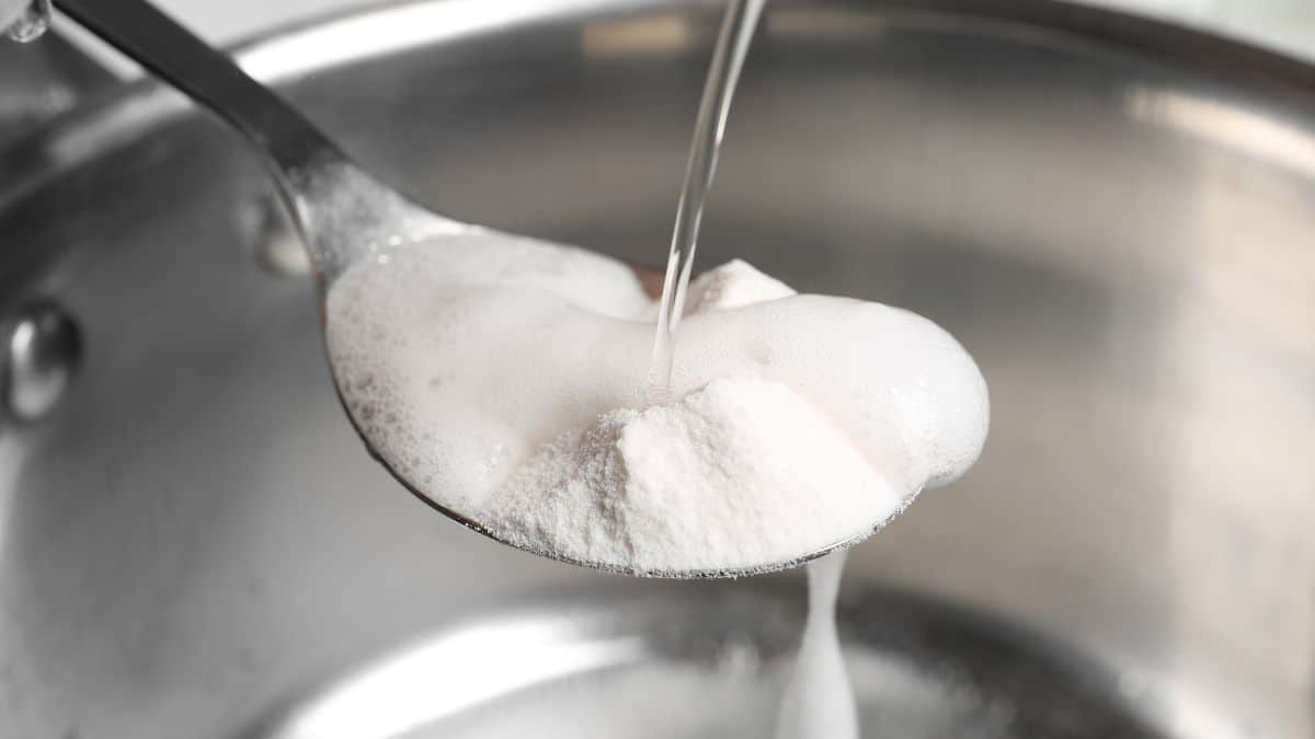 Vinegar being added to a spoonful of baking soda.