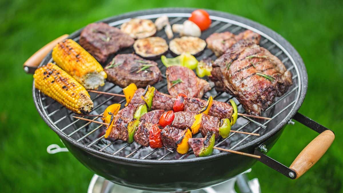 Meat and veggies on an outdoor grill.