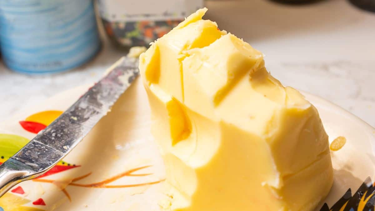 A block of soft butter on a white plate.