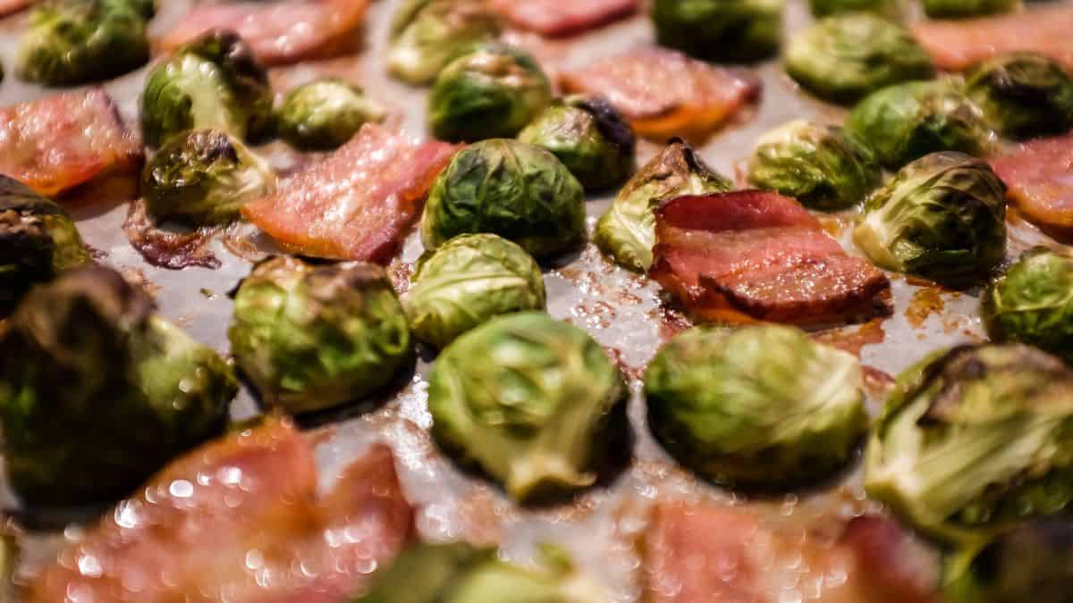 Brussels sprouts and bacon on a baking sheet.