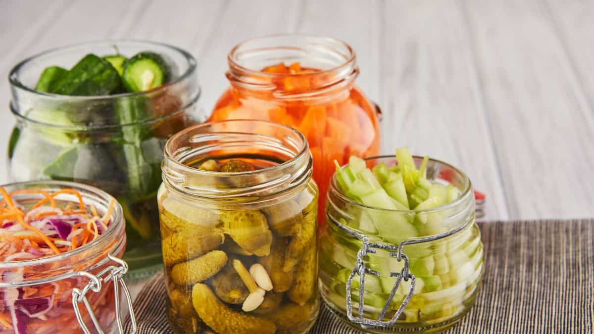 Various pickled vegetables in glass jars.