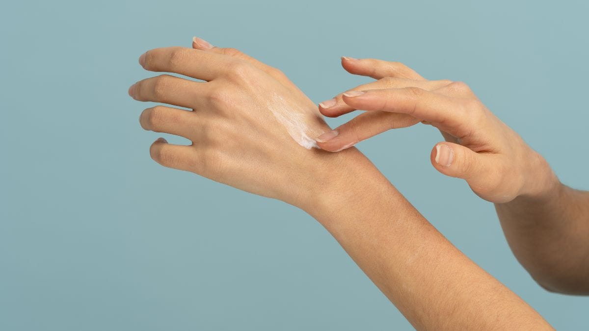 Woman moisturizing hands.