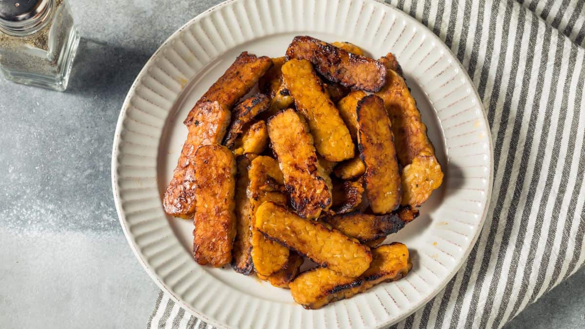 Tempeh bacon on a white plate.