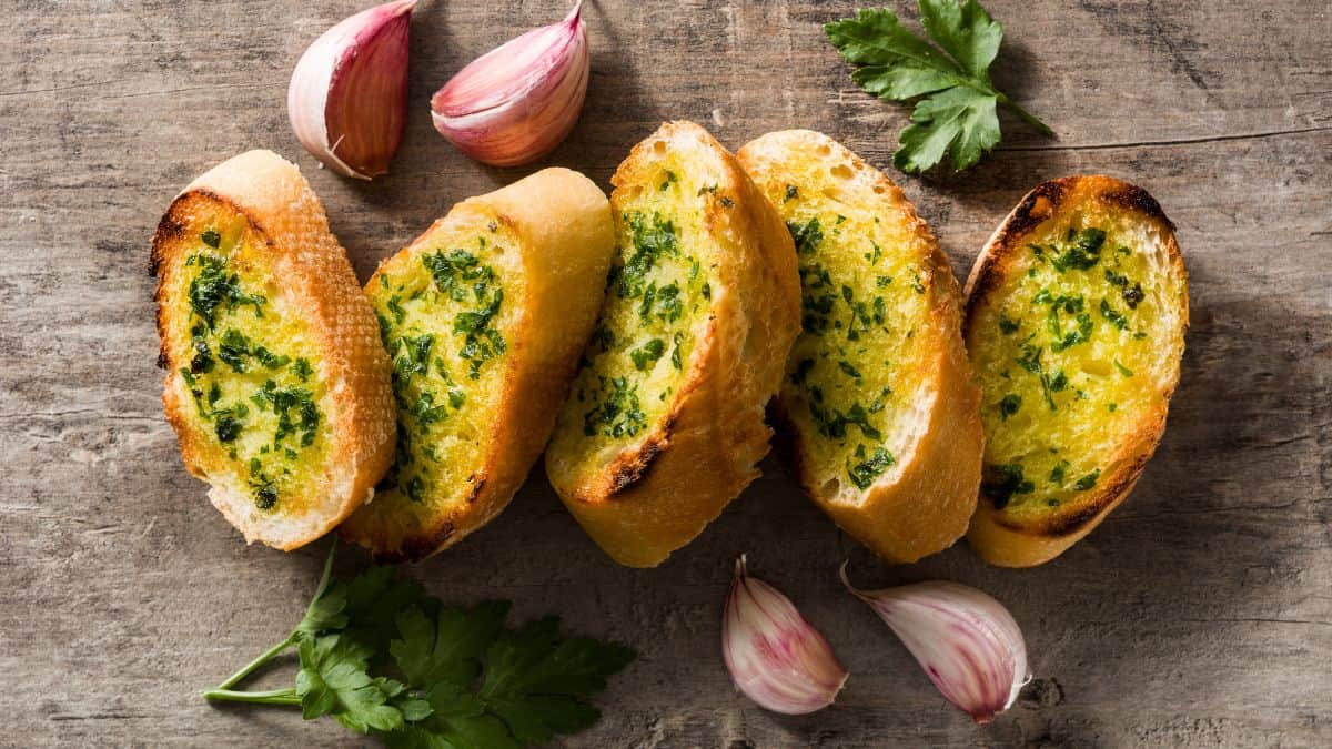 Slices of garlic bread on a wooden board.