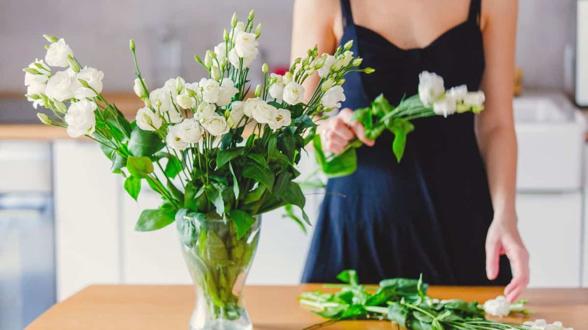 Woman removing wilted flowers.