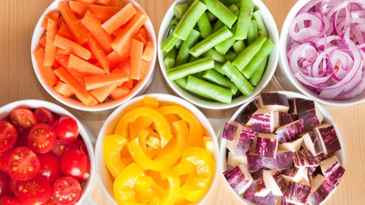 Cut vegetables in white bowls.