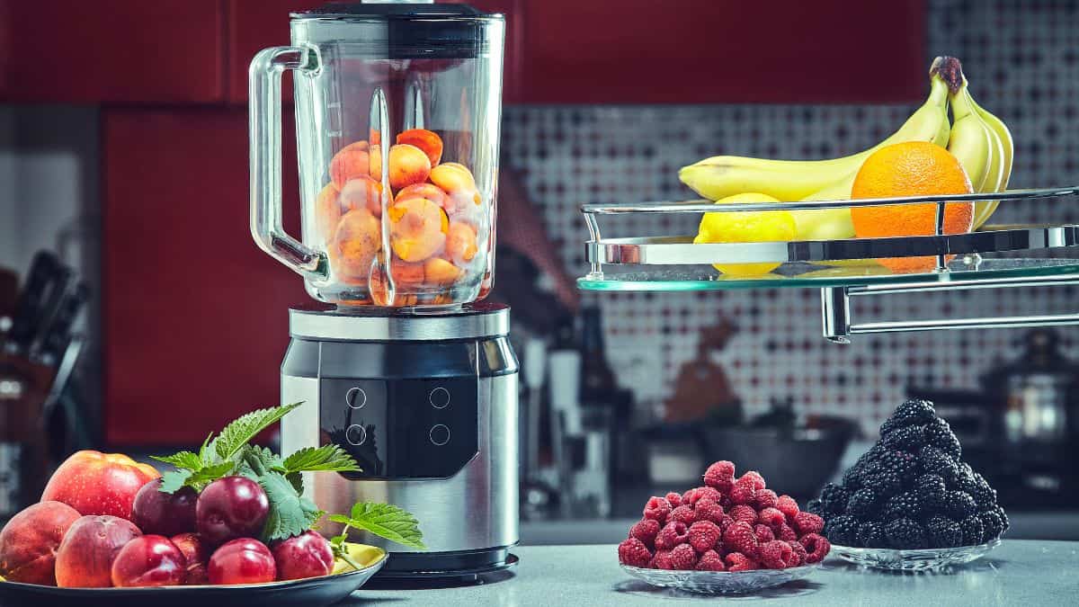 Blender and fruits on a kitchen counter.