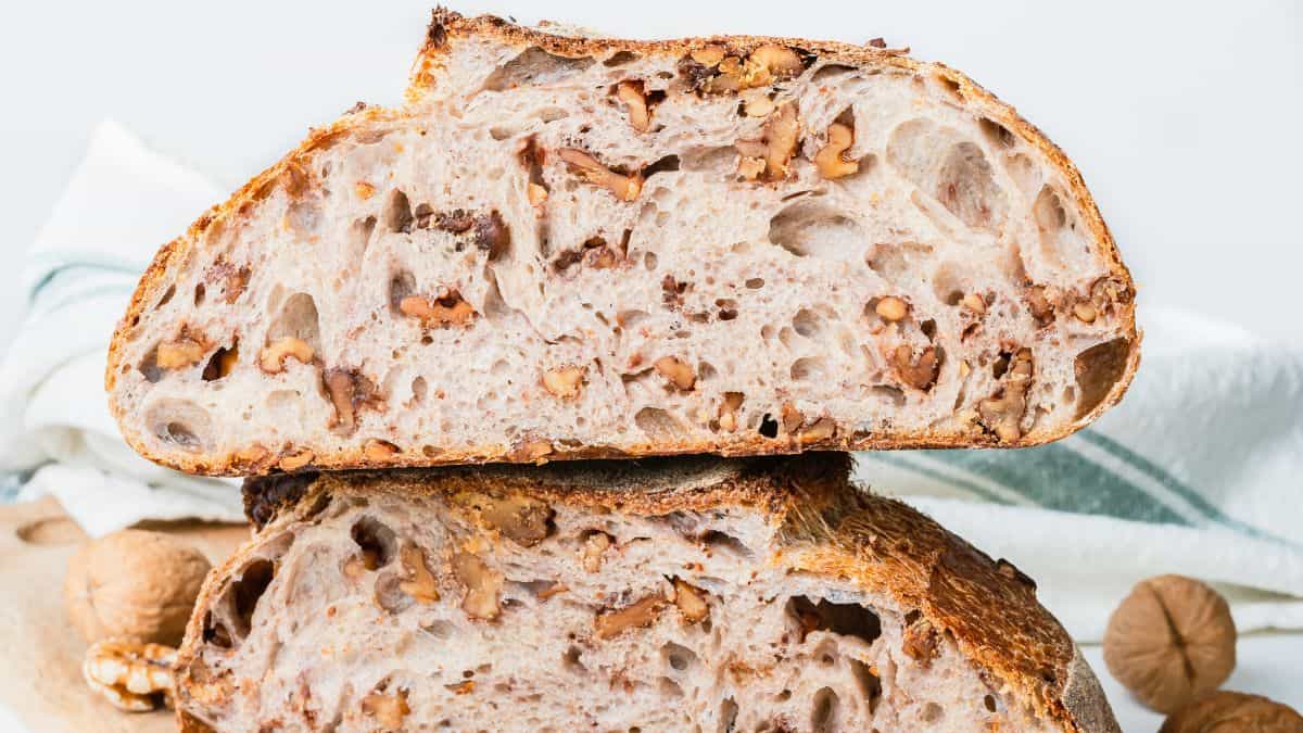 Walnut sougdough bread with walnuts in the background.