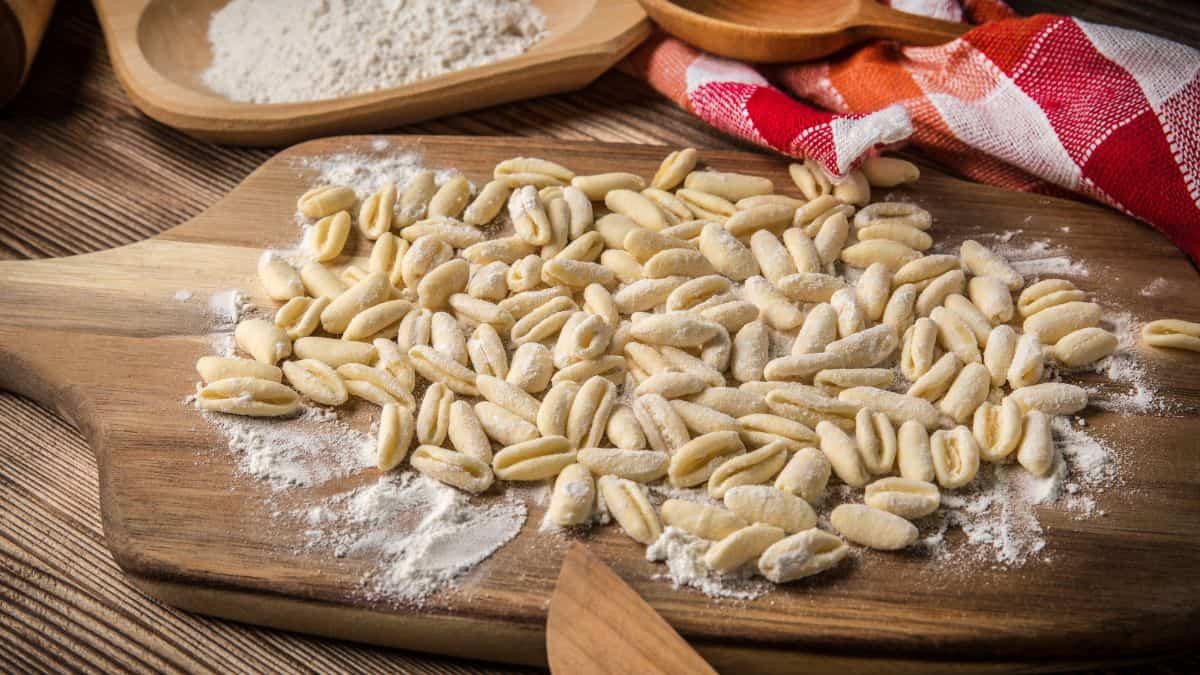 Fresh cavatelli pasta on a wooden board.