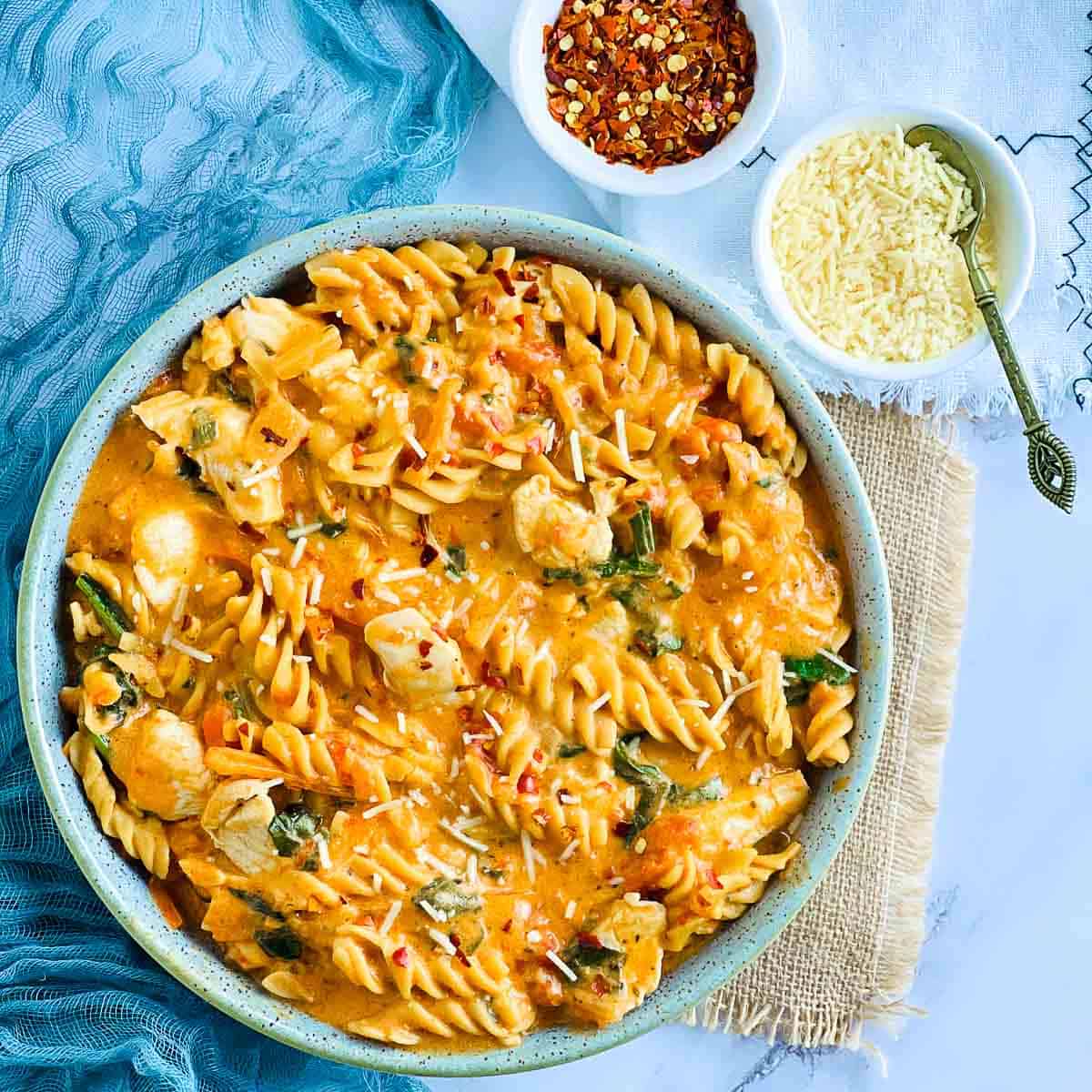 Chicken chickpea pasta served in a green bowl.