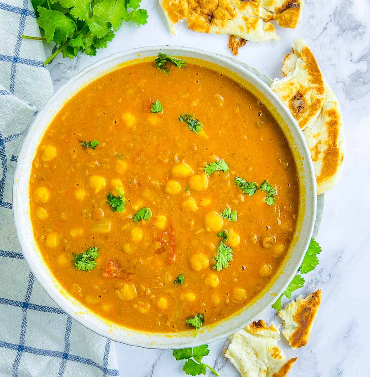 Chickpea lentil curry bowl on a marble surface.