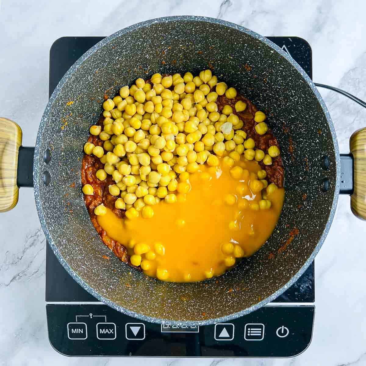 Mango puree and cooked chickpeas added to the pot.