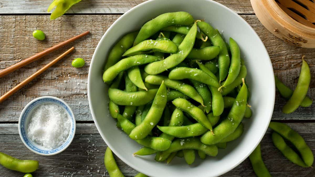 Green edamame in a white bowl.