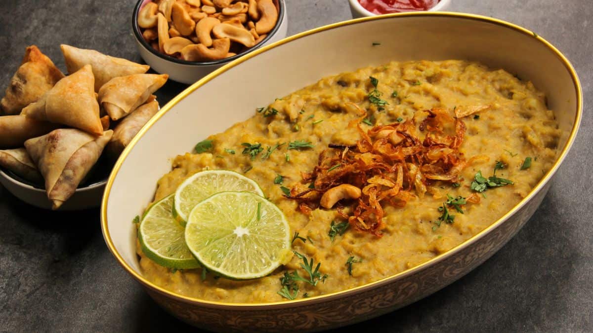 Haleem topped with fried onion and lime slices.