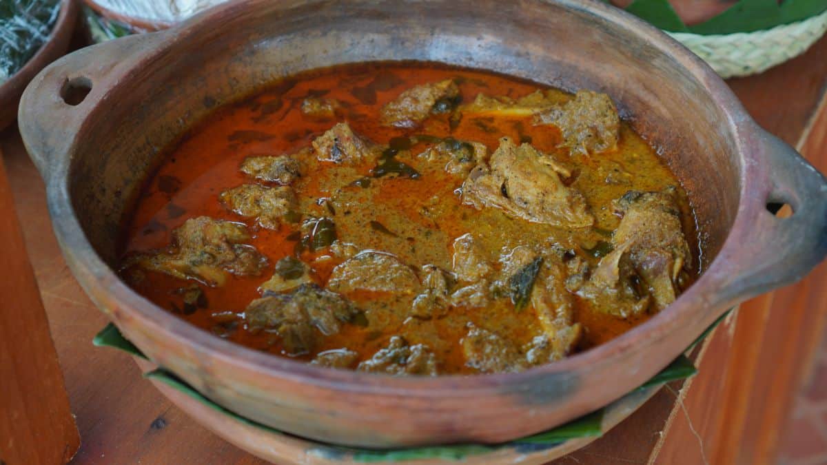 Trini duck curry in a rustic bowl.