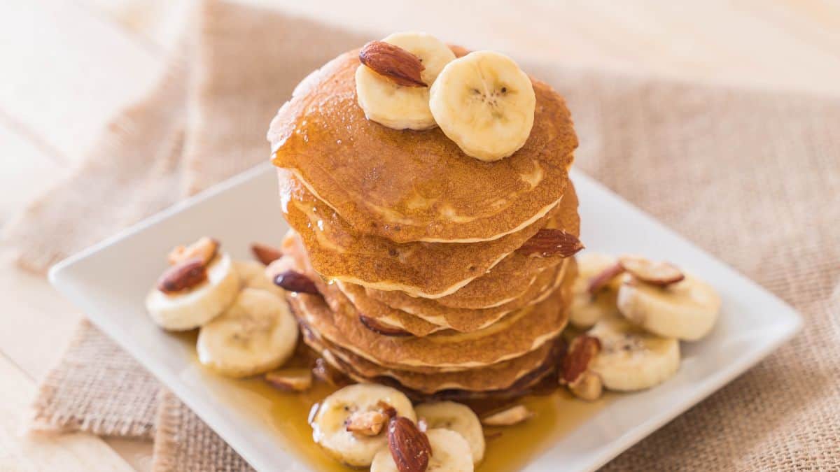 A stack of almond pancakes on a white plate.