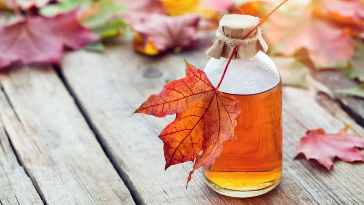 A bottle of maple syrup on a wooden surface.