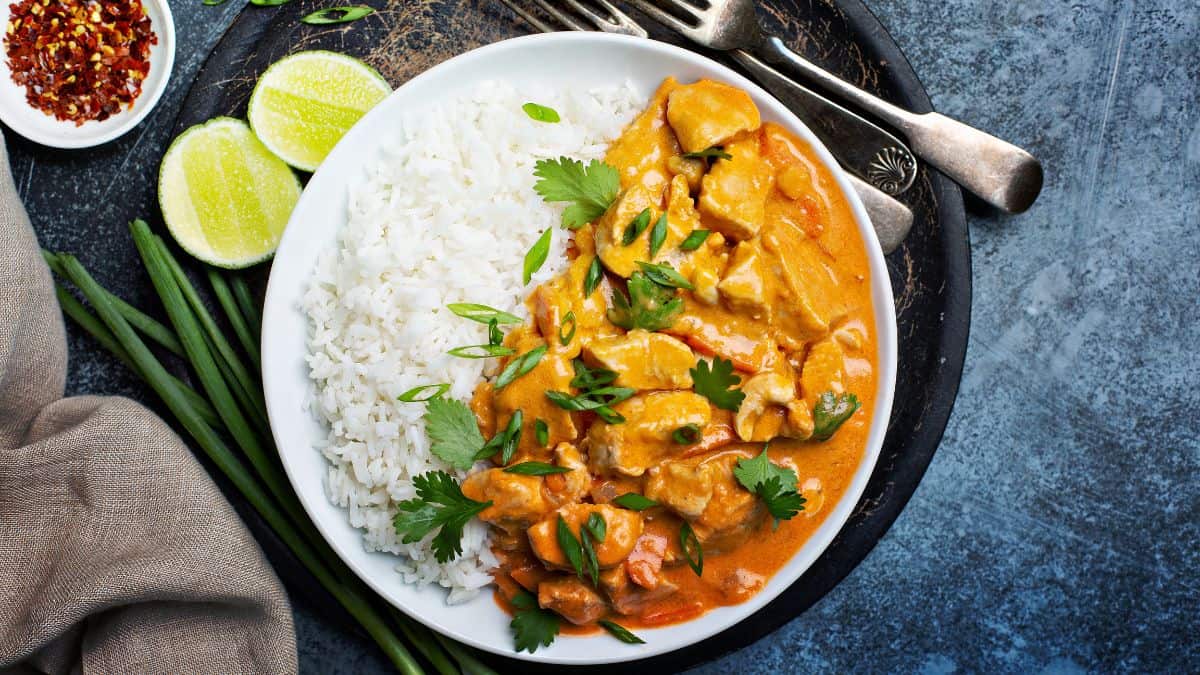 Chicken curry served with rice on a plate.