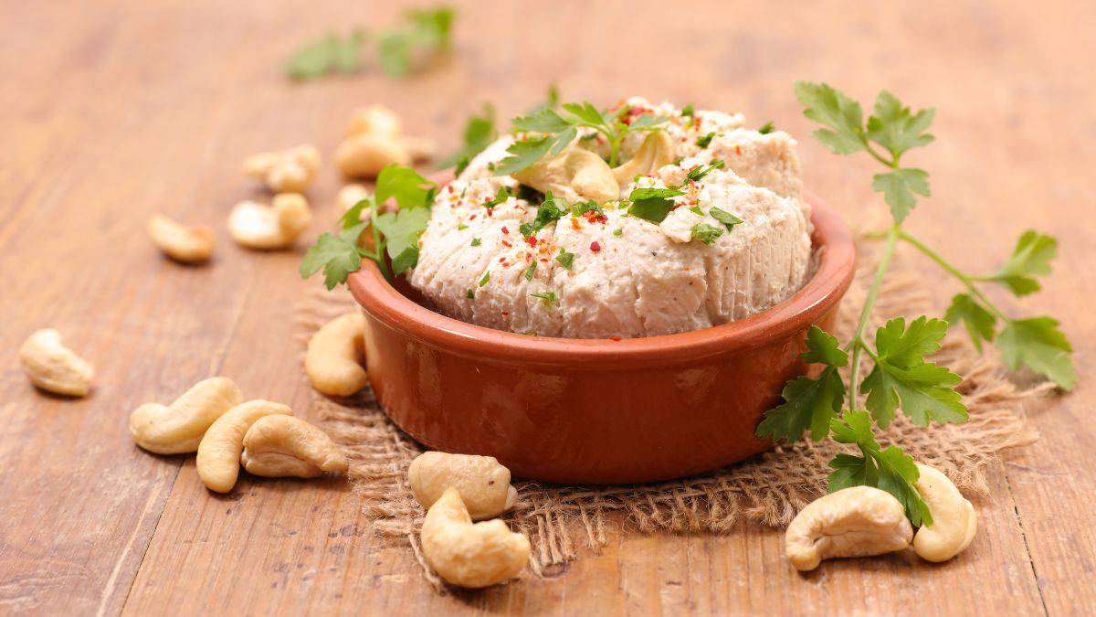 Cashew cheese in a white bowl garnished with cilantro.