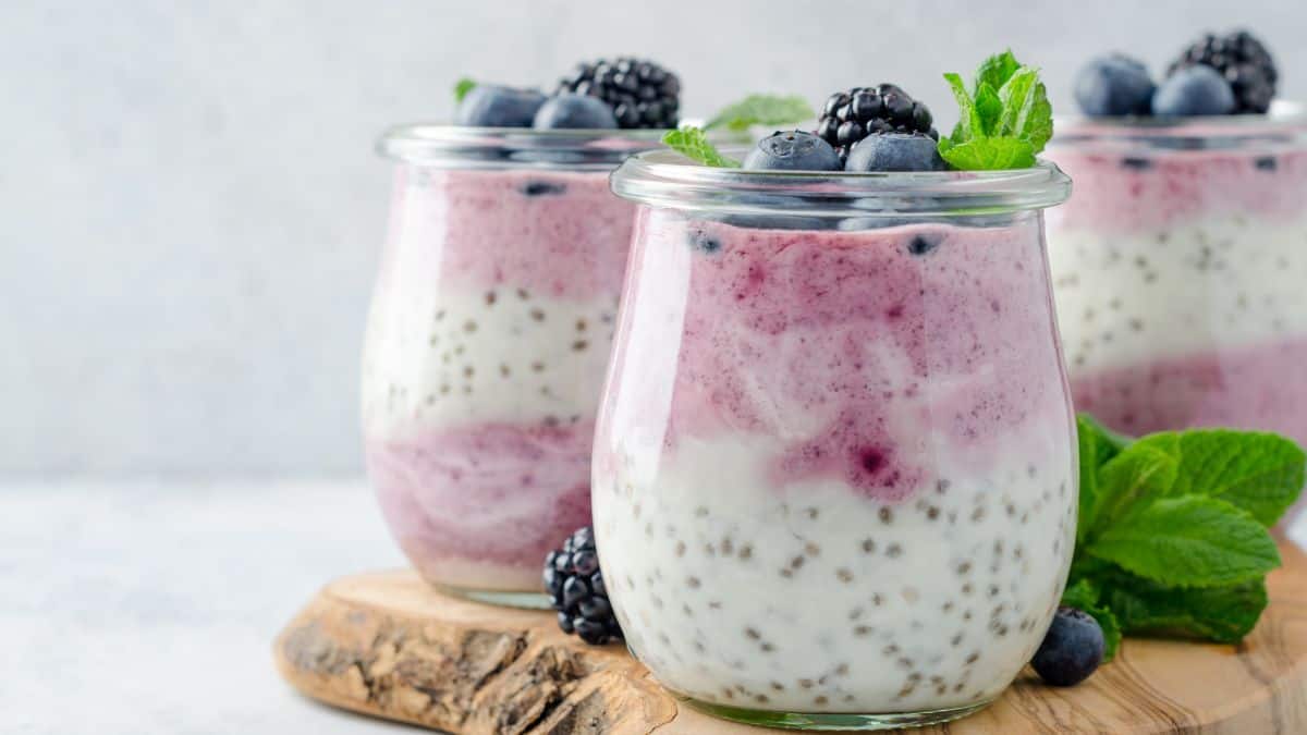 Two glasses of chia pudding topped with berries.