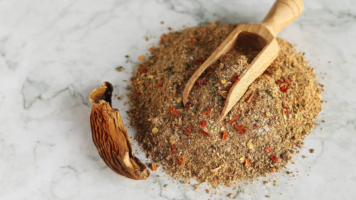 Mushroom powder on a marble surface with a wooden spoon.