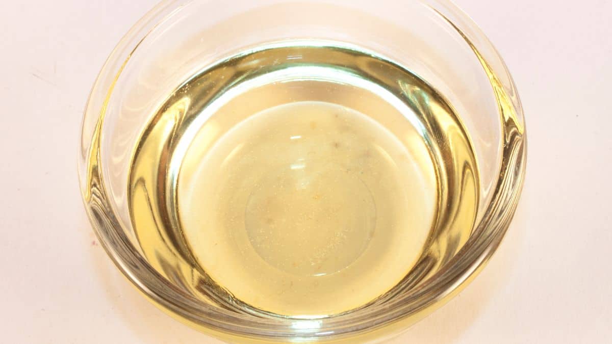 A bowl of champagne vinegar on a brown surface.