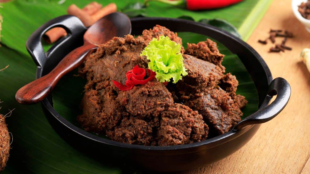 Beef rendang in a black bowl.