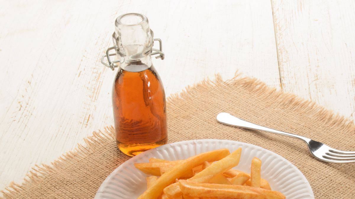 Malt vinegar served with a plate of chips.