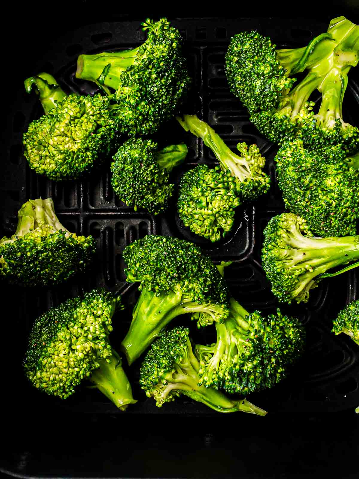 Seasoned florets in air fryer basket.