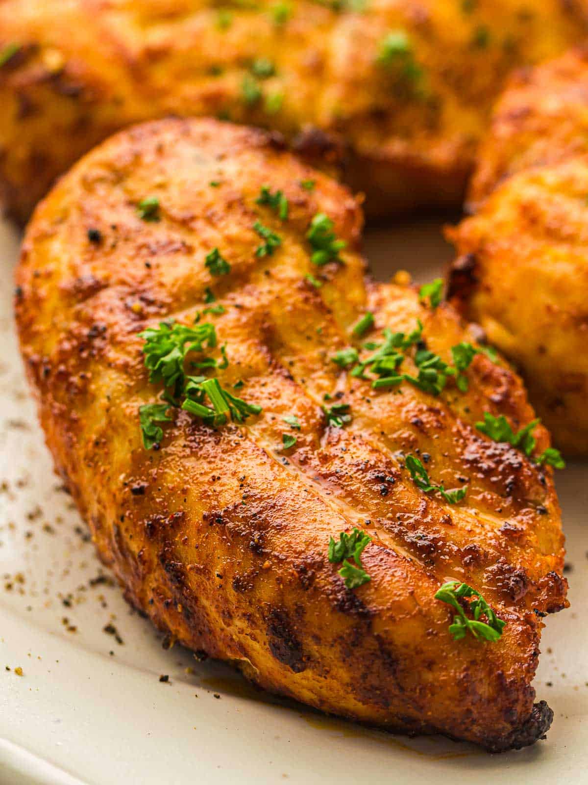 Air fryer chicken breast garnished with finely chopped parsley.