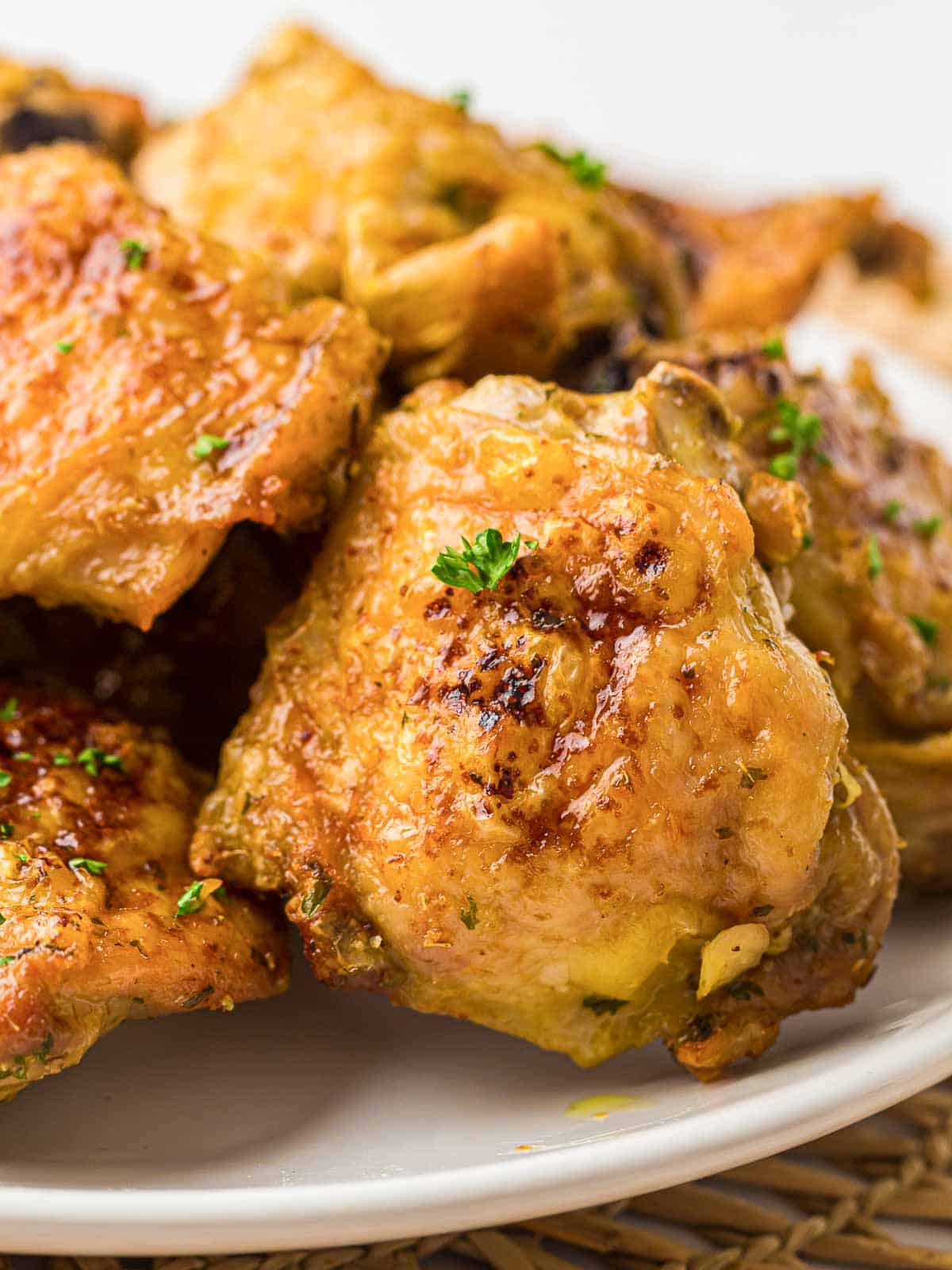 Air fryer chicken thighs on a white plate.