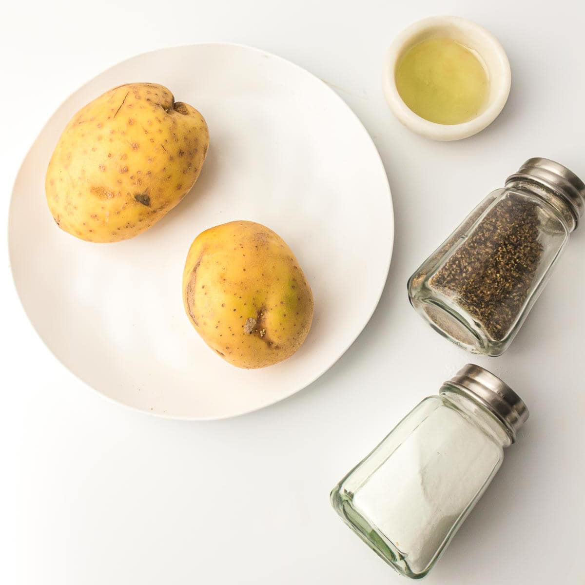 Ingredients to make fries on a white surface.