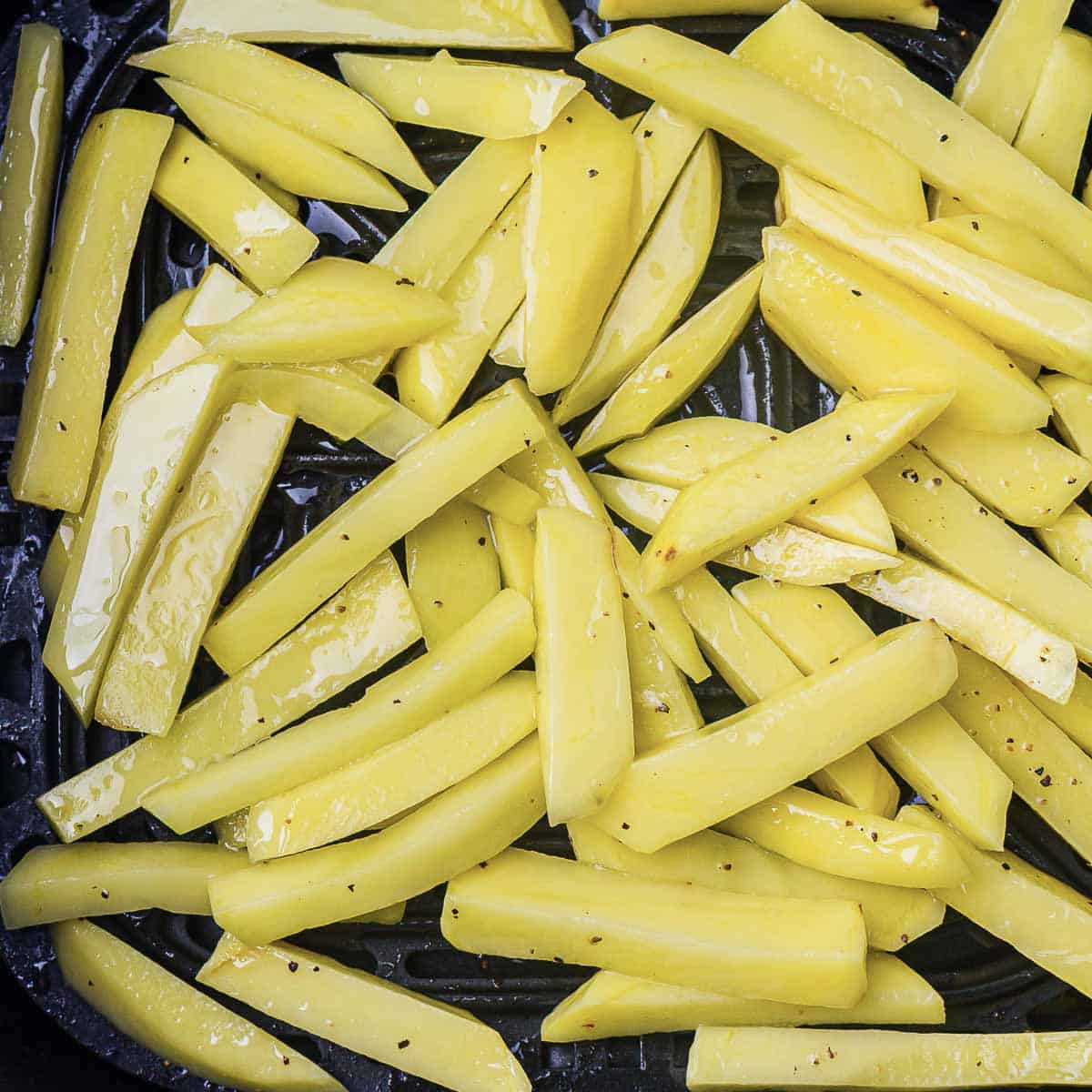 Potatoes layered in air fryer.