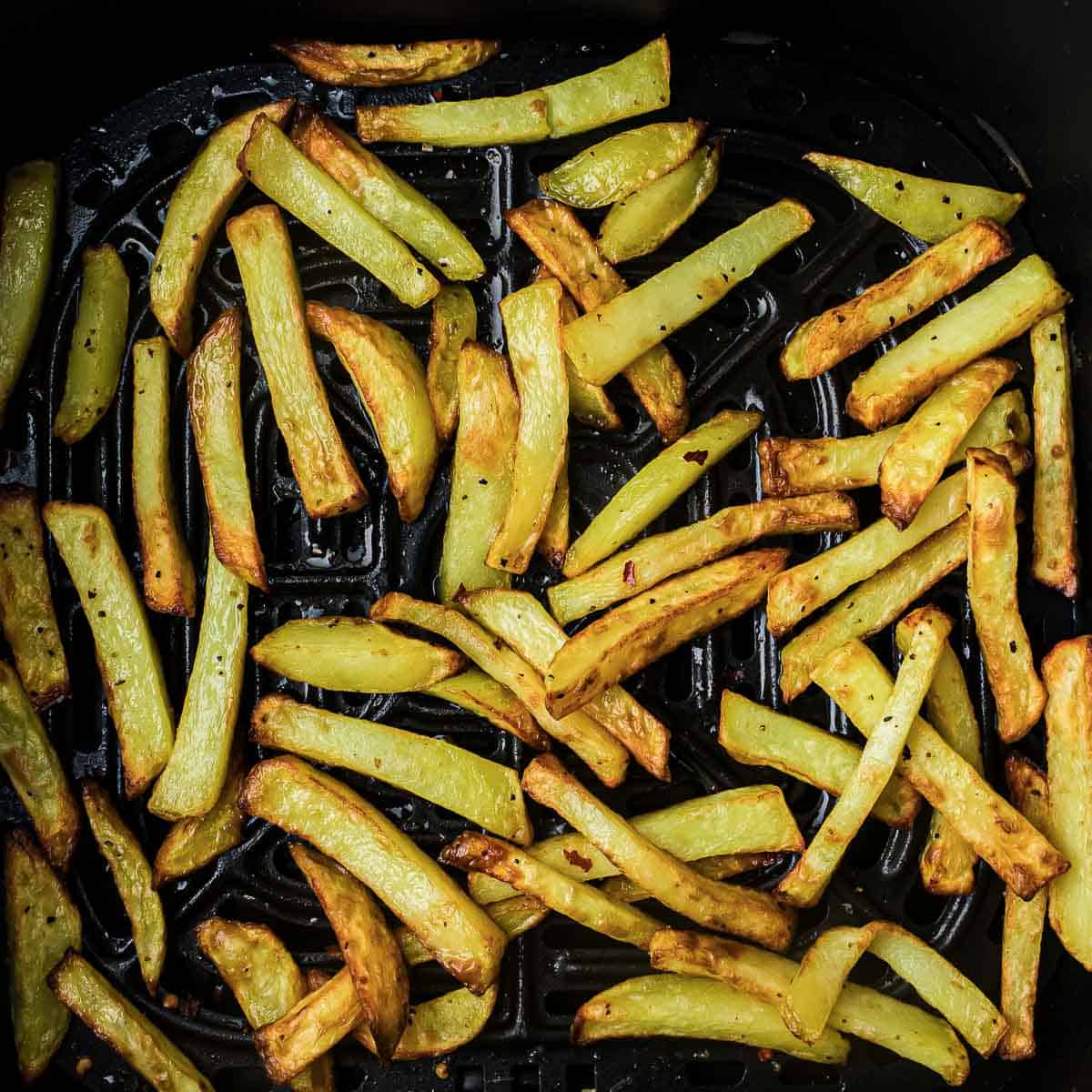 Air-fried fries in the air fryer basket.