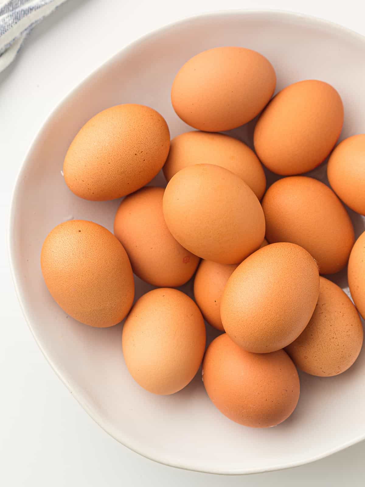 Raw eggs in a white bowl.