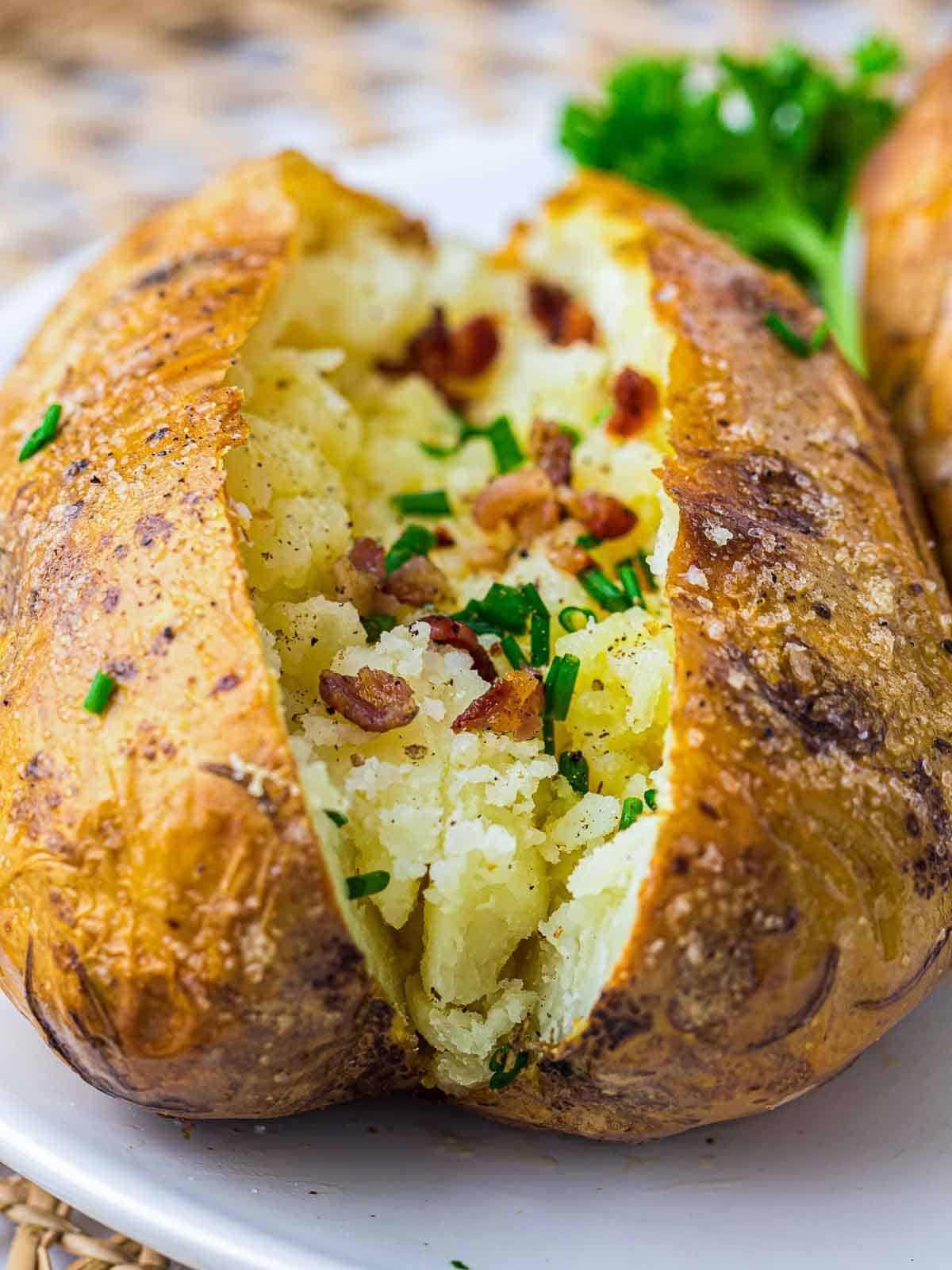 Side view of jacket potatoe on a white plate.