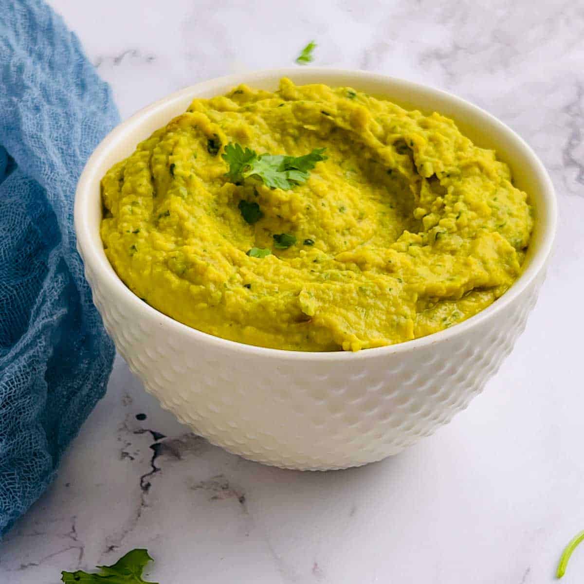 White bean dip bowl topped with cilantro.