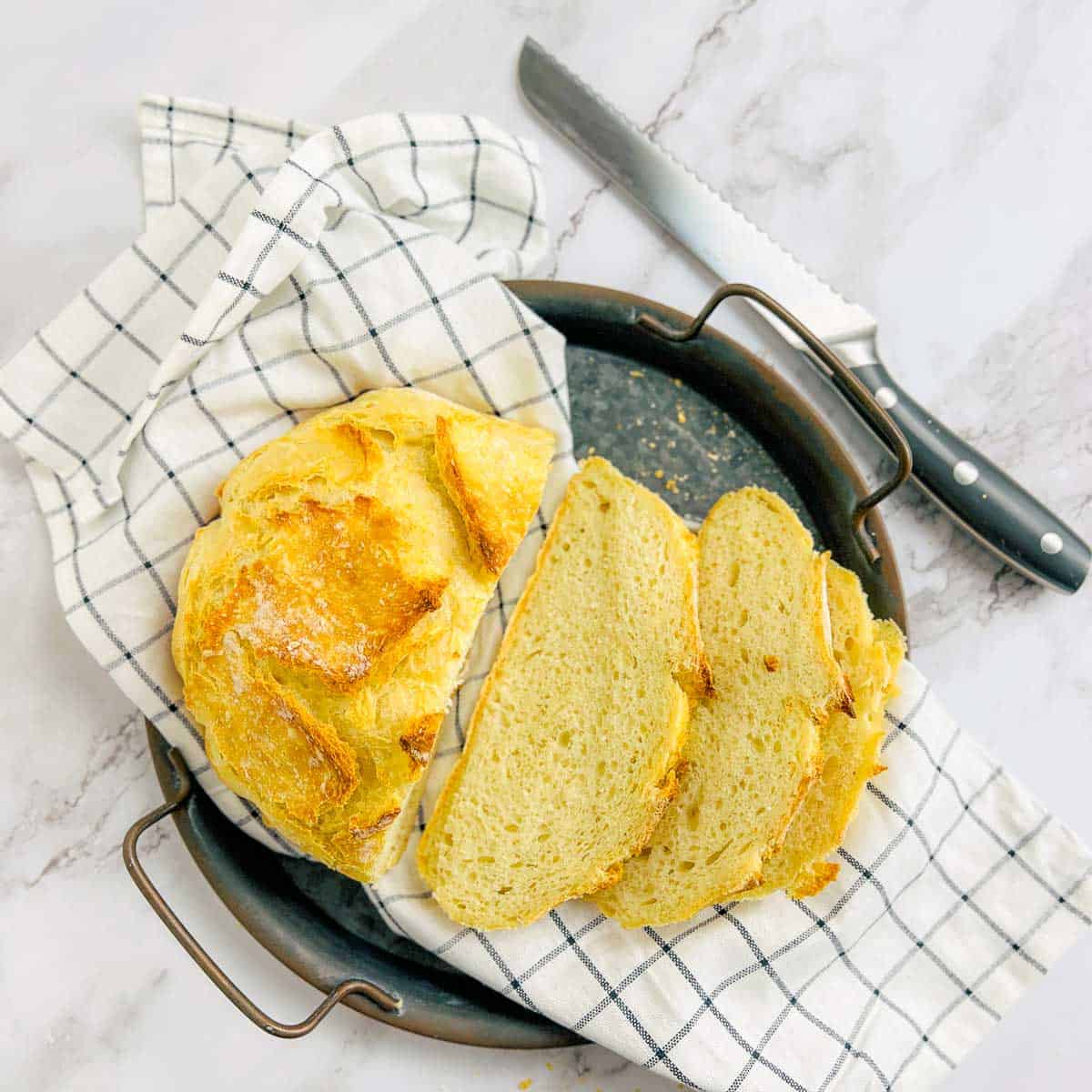 No-knead yeast bread sliced and placed on a black plate.