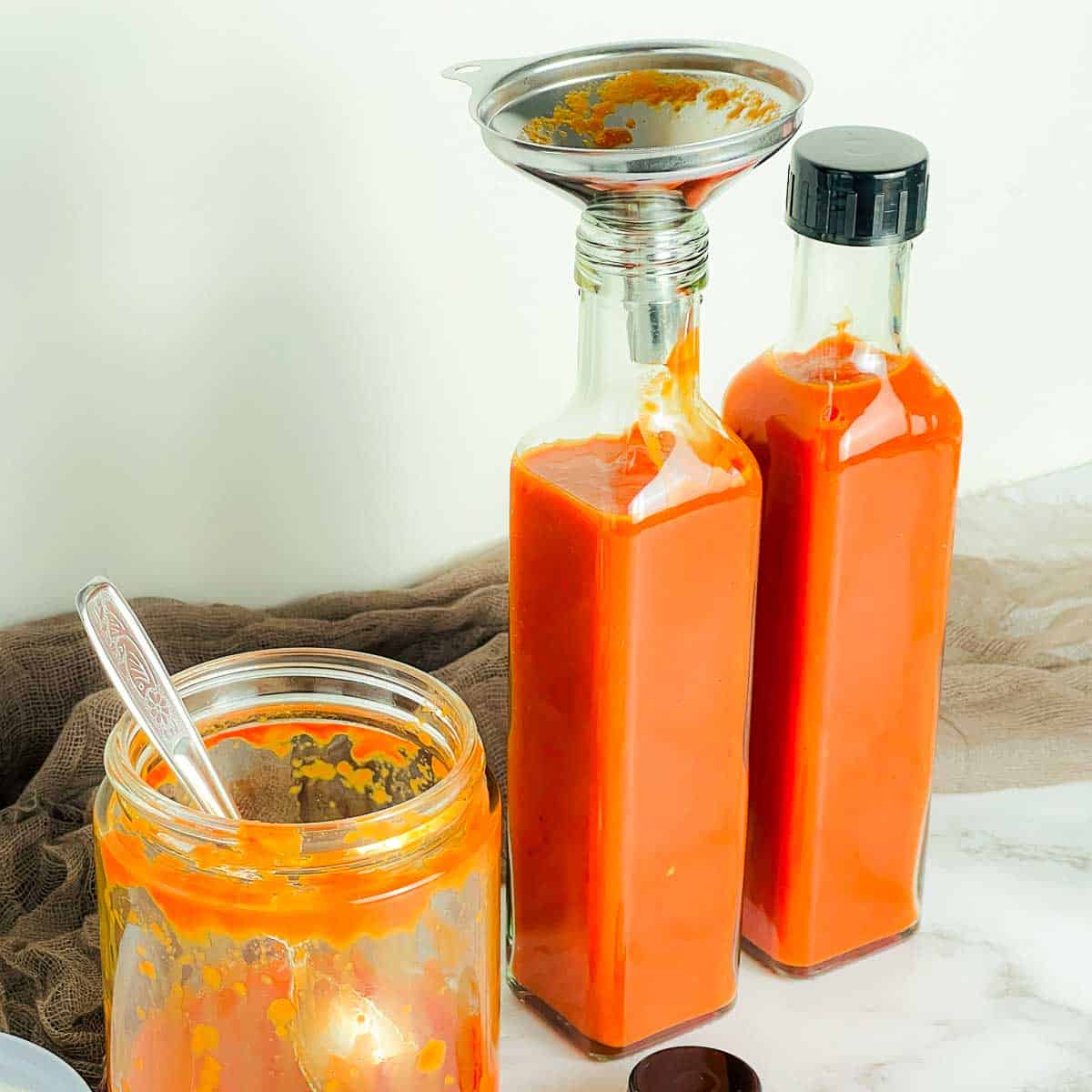 Being poured into sauce bottles.