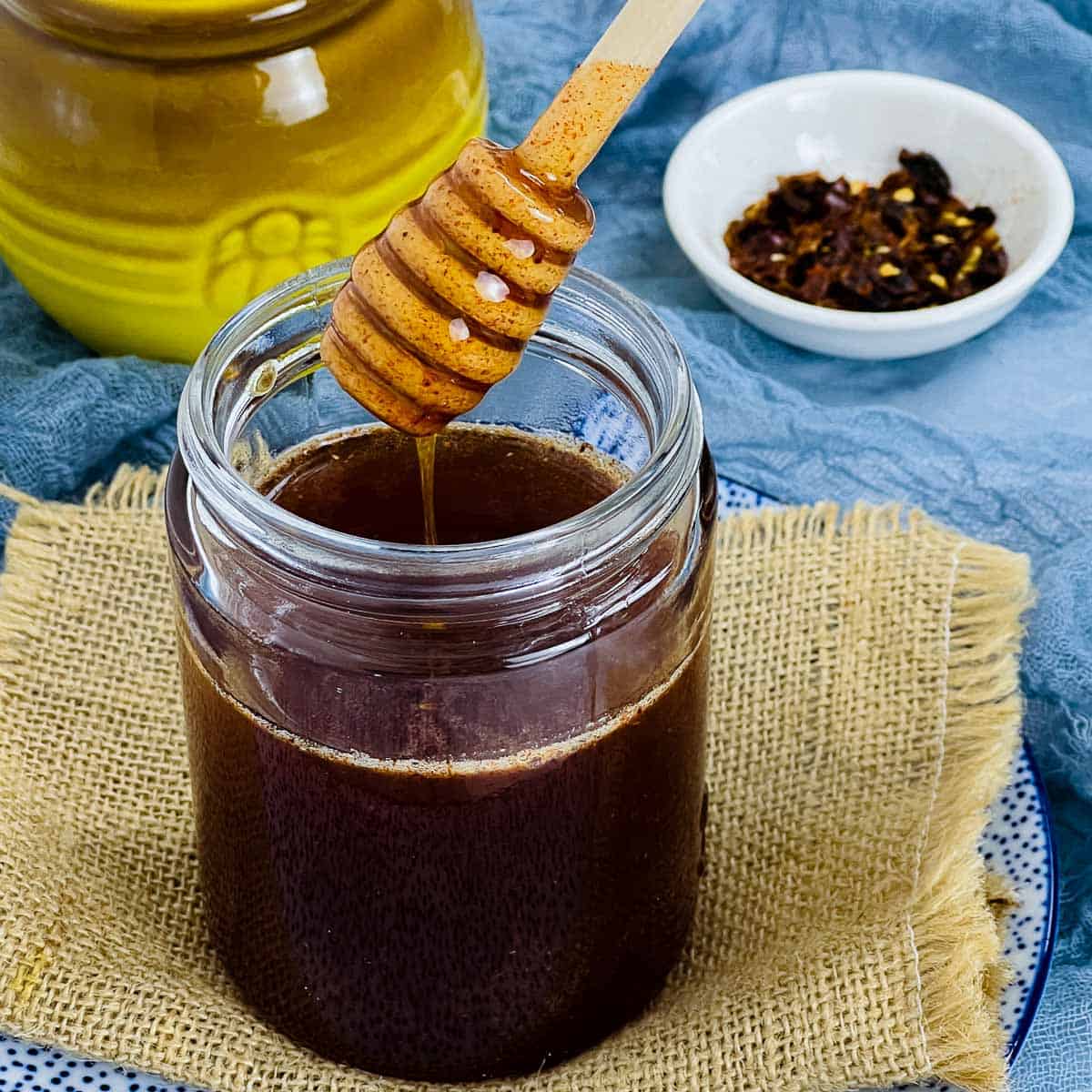 Hot honey in a jar with honey spoon dipped in it.