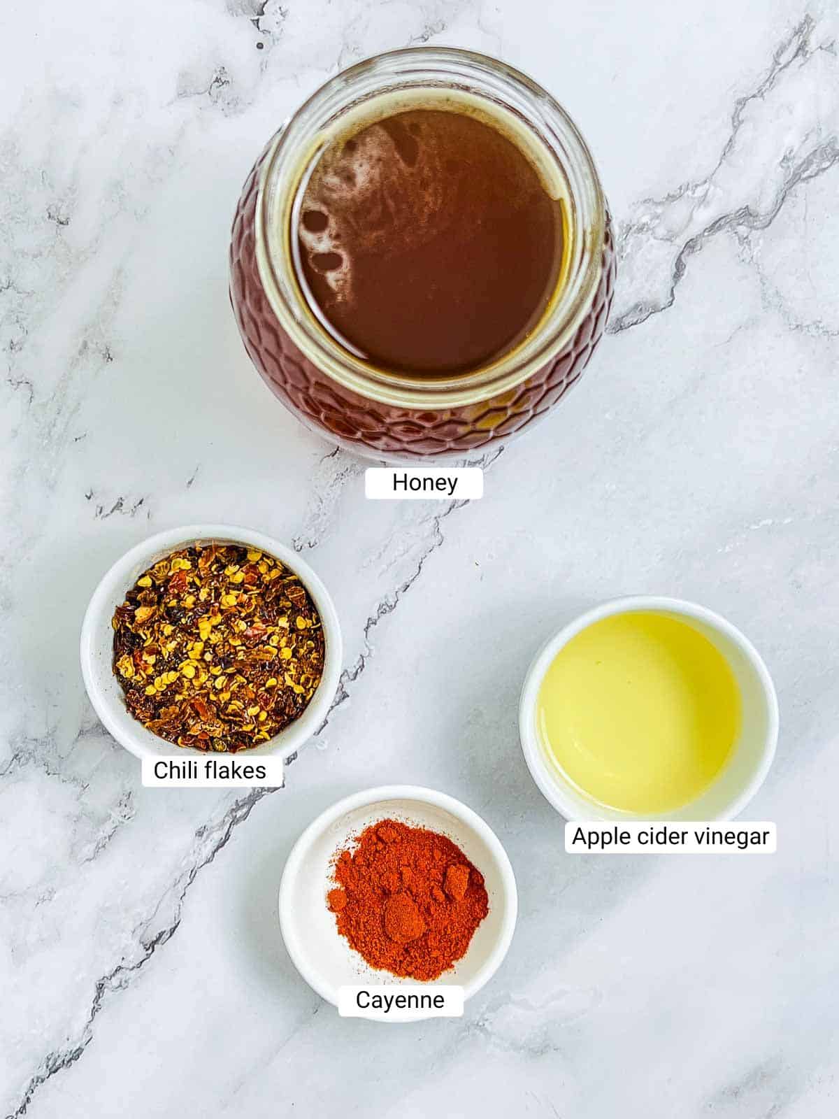 Ingredients to make hot honey on a marble surface.