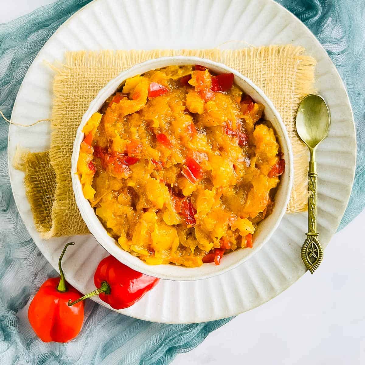 Pineapple habanero chutney in a small bowl with a spoon.