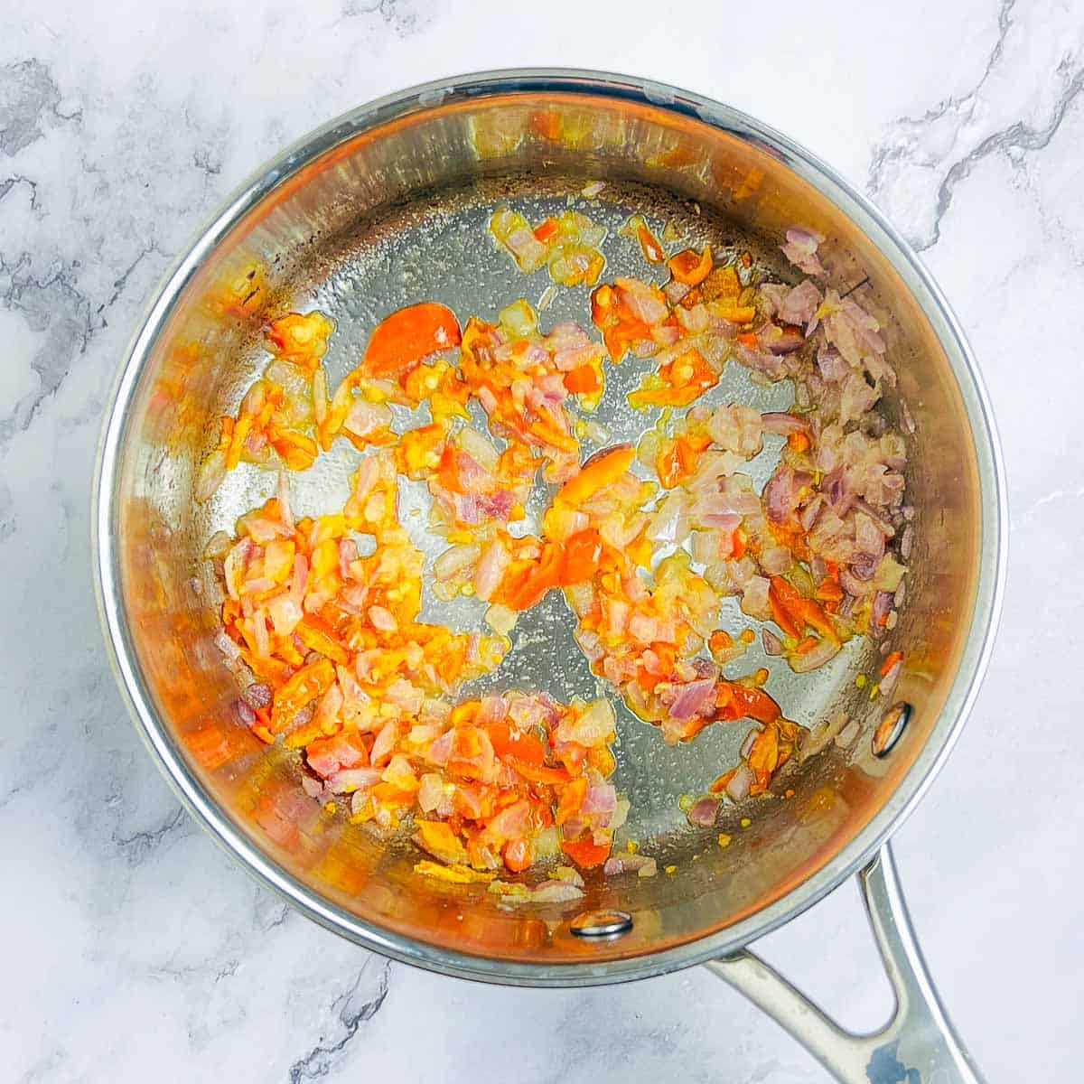 Sauteed onion and habanero chili in a saucepan.